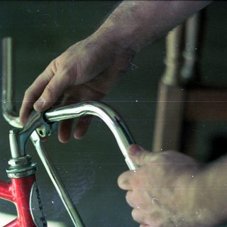 Person adjusting bicycle handlebar stem.