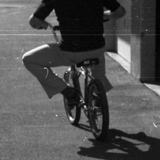 Person riding red bicycle on paved path.