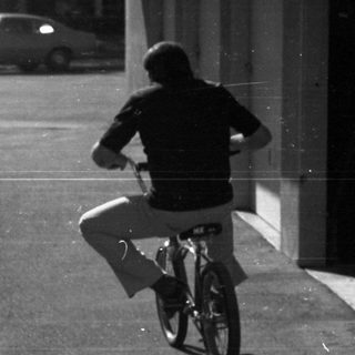Person riding red bicycle on paved path.