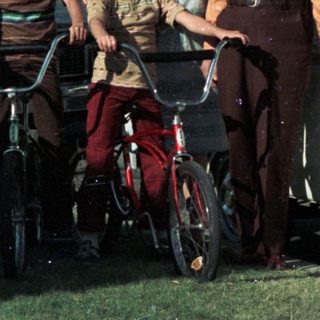 Family posing with bicycles and vintage van.