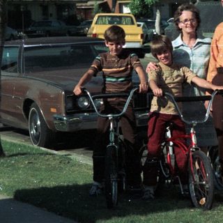 Family posing with bicycles and vintage van.