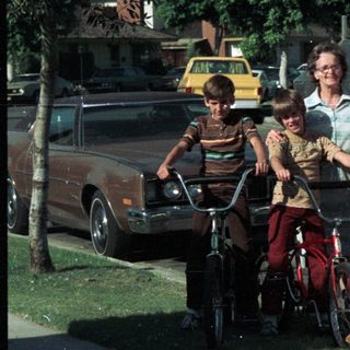 Family posing with bicycles and vintage van.