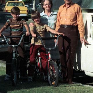 Family posing with bicycles and vintage van.