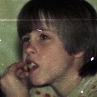 Child sitting at vintage table eating.