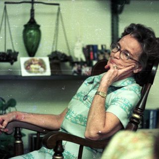 Woman resting thoughtfully in armchair at home.