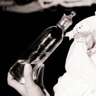 A woman baptizing an infant with holy water.