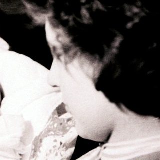 A woman baptizing an infant with holy water.