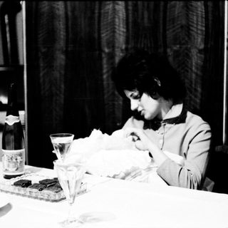 Woman sitting alone at table eating.