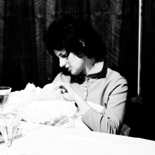 Woman sitting alone at table eating.