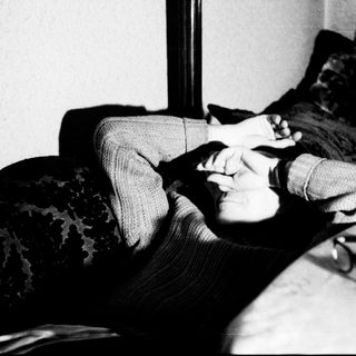 Person lying on floor holding phone.