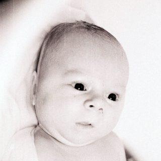 Tender moment of infant being held.