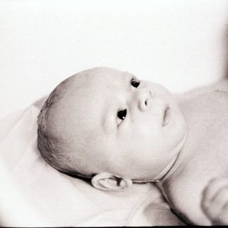 Infant lying peacefully on back.
