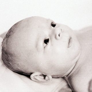 Infant lying peacefully on back.