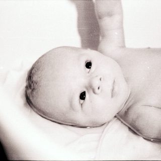 Baby lying in a bathtub.