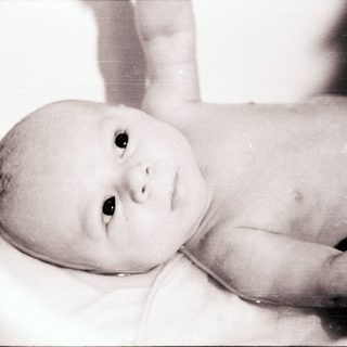 Baby lying in a bathtub.
