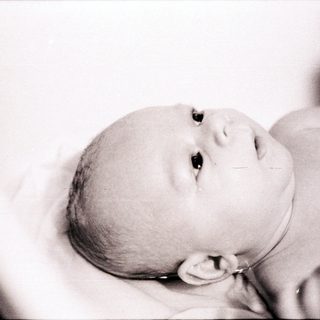 Newborn infant resting peacefully in swaddle.