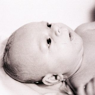 Newborn infant resting peacefully in swaddle.