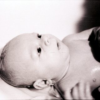 Newborn infant resting peacefully in swaddle.