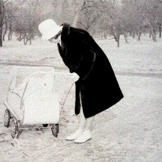 Person clearing snow from small vehicle in winter.
