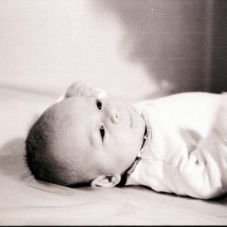 Infant lying peacefully on bed.
