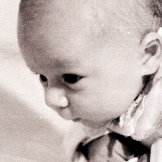 Baby lying on stomach, exploring surface.