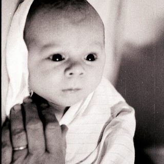 Tender moment of an infant being held.