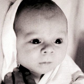 Tender moment of an infant being held.