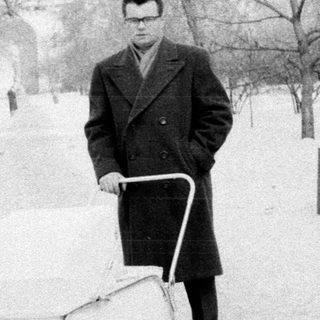 Man pushing cart in snowy park.