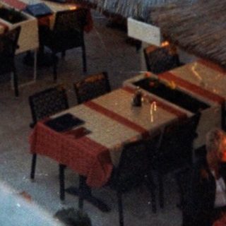 Tropical beachside restaurant with thatched umbrellas.