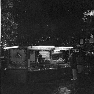 Nighttime street scene with festive decorations and a clock showing 1:14.