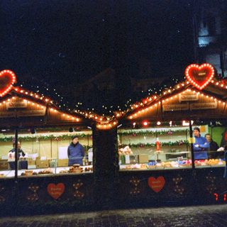 Christmas market stalls with festive lights.