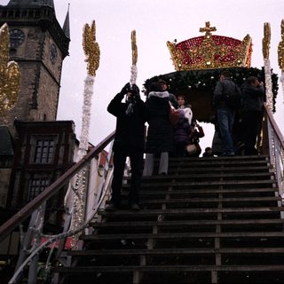 Christmas market scene with festive carousel and decorated stairs.