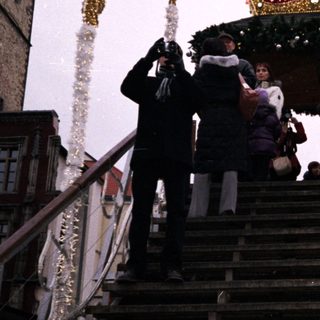 Christmas market scene with festive carousel and decorated stairs.