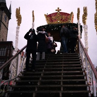 Christmas market scene with festive carousel and decorated stairs.