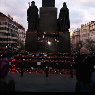 Statue with memorial candles and figures.
