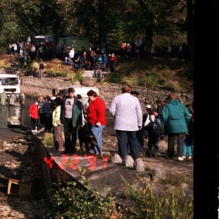 People gathering by a lake for outdoor activities.