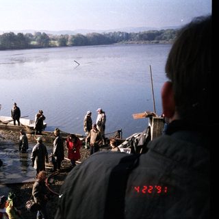 Fishing activity on a lake with boats and people.