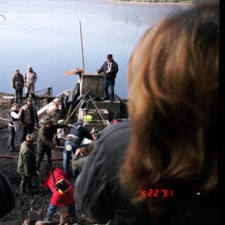 People gathered by a lake during a fishing event.