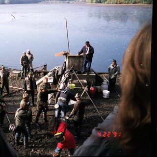 People fishing and working on a lake shore.