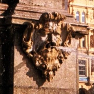 Baroque fountain with water spout in historic European square.