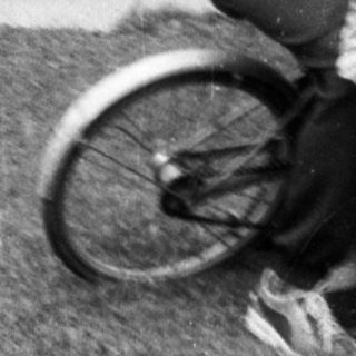Two children joyfully hugging on a bicycle.