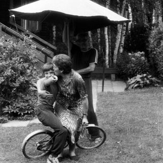 Family enjoying outdoor moment with bicycle.