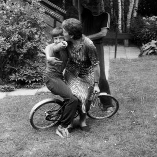 Family enjoying outdoor moment with bicycle.