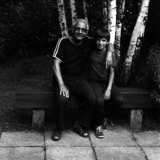 Two people posing together outdoors near birch trees.