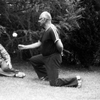 Three people playing outdoor game with flower petals.