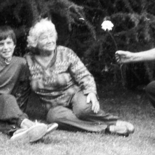 Three people playing outdoor game with flower petals.