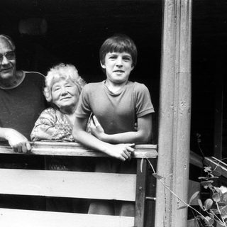 Family posing together on wooden balcony.