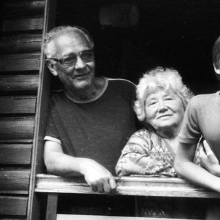 Family posing together on wooden balcony.