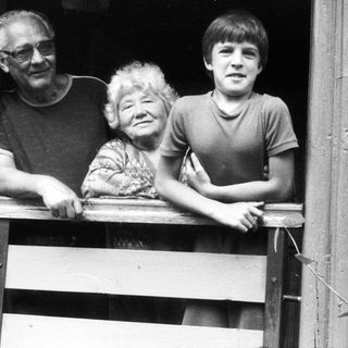 Family posing together on wooden balcony.
