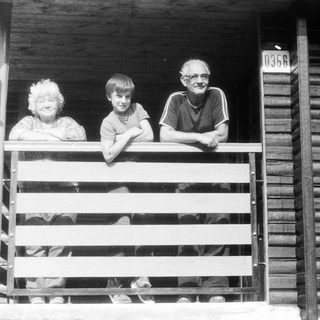 Family posing on wooden porch steps.